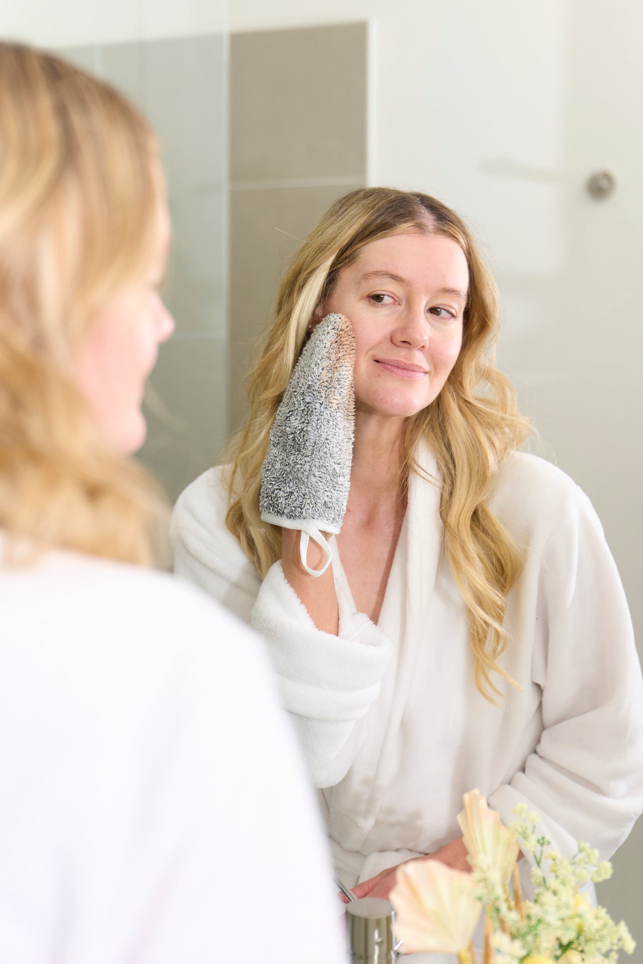 Image of a woman effortlessly removing makeup with the Suzi Kozmetika makeup remover glove, showcasing its ease of use and effectiveness.